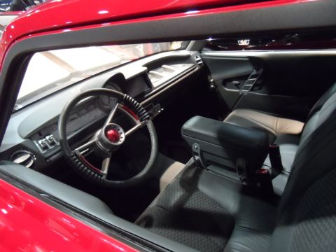 1971 Ford Ranchero - The interior of a red classic car, likely a 1971 Ford Ranchero, is shown with a focus on the steering wheel and dashboard. The custom steer…