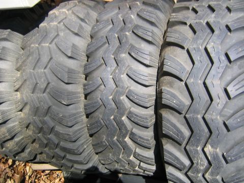 1978 Ford Bronco - Close-up view of stacked off-road tires with deep, aggressive tread patterns visible.