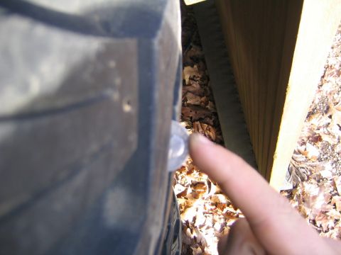 1978 Ford Bronco - A finger points to a small circular emblem on the fender of a 1978 Ford Bronco.