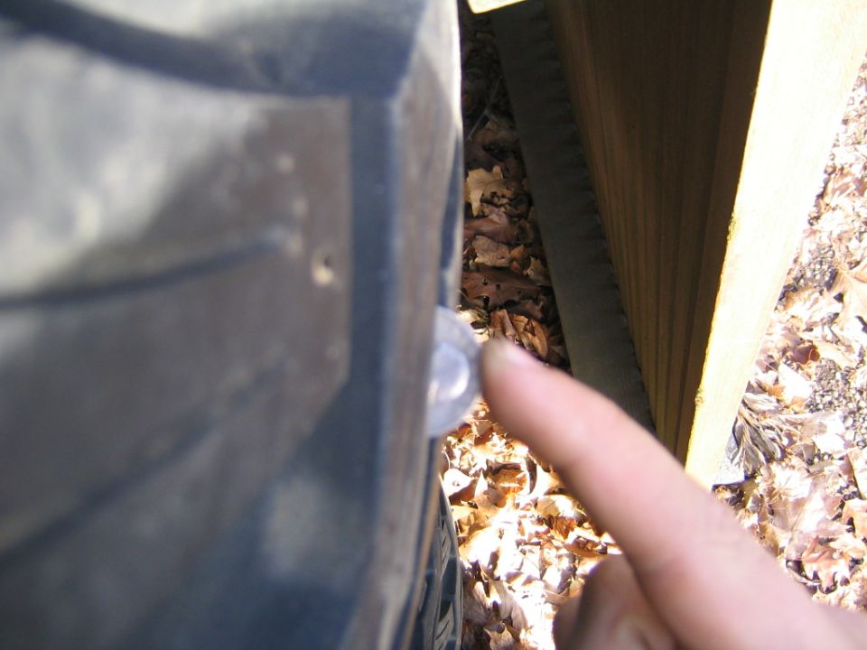 1978 Ford Bronco fender with a finger pointing to a small circular emblem