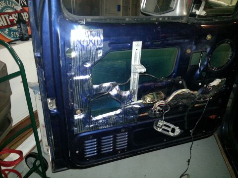 1994 Ford Bronco - Photograph of a vehicle door interior with regulator and wiring, not a technical document.