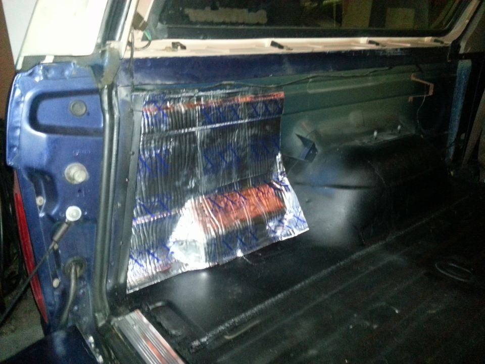 Interior cargo area with sound deadening material applied to the side panel