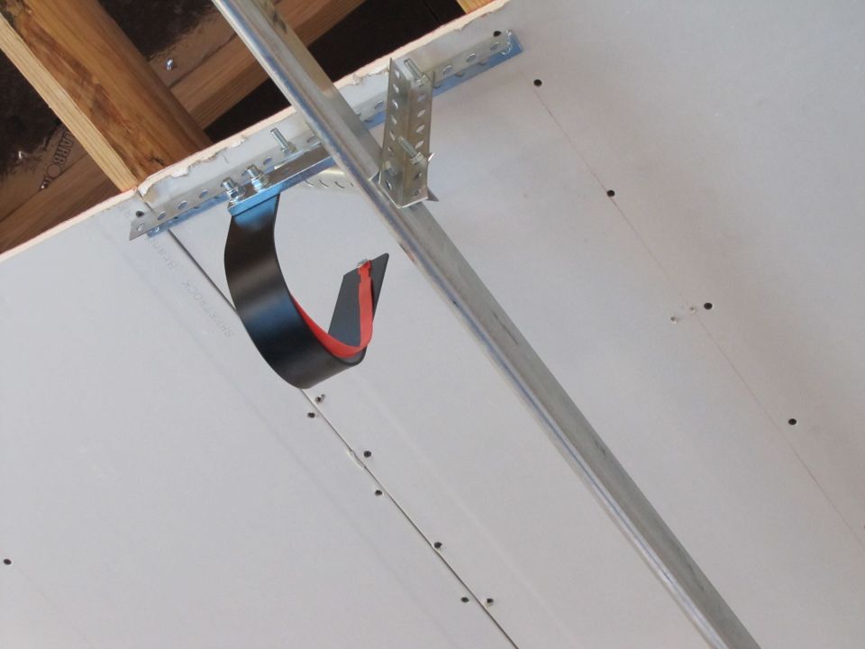 Ceiling under construction with drywall, metal framing, and a hanging strap.