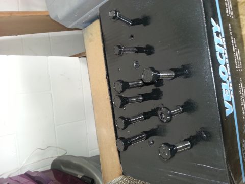 1994 Ford Bronco - A box of Velocity brake shoes is displayed with bolts arranged on a black backing board.