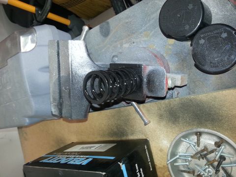 1994 Ford Bronco - A black spring is secured in a vise, with a box of Velocity parts visible in the foreground.