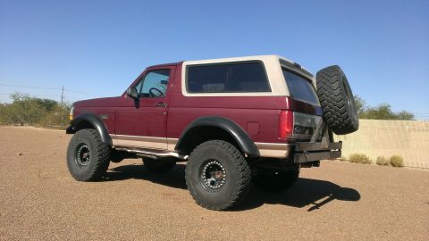 1996 Ford Bronco - This 1996 Ford Bronco features a two-tone paint scheme and off-road tires, with a spare tire mounted on the rear.