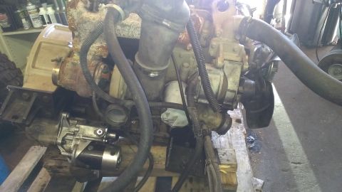1996 Ford Bronco - Close-up view of a disassembled engine, showing various components like the starter and turbo.