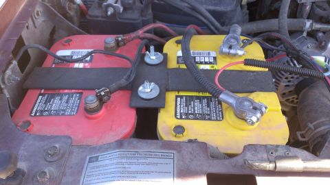 1996 Ford Bronco - Dual Optima batteries installed in the engine bay of a vehicle. The Supermotors.net logo is visible in the lower right corner.