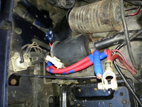 1994 Ford Bronco - Close-up of engine bay wiring, showing insulated cables and battery terminal connections.