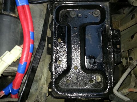1994 Ford Bronco - Close-up of a vehicle's battery tray, with wiring visible.