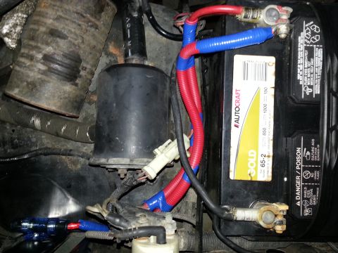 1994 Ford Bronco - Close-up view of a vehicle's engine bay, focusing on the battery and its associated wiring.