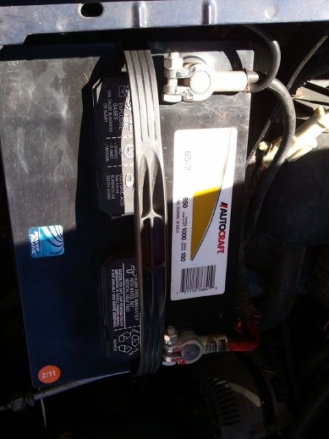 1994 Ford Bronco - Close-up of a car battery, showing its brand and some safety information.