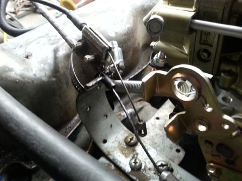 1981 Ford Bronco - Close-up view of a carburetor linkage mechanism with visible throttle cable and spring assembly.