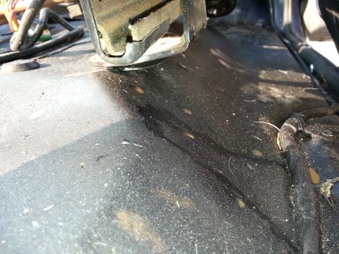 1994 Ford Bronco - The floor of this vehicle's interior is covered in dust and debris, with some wiring visible.