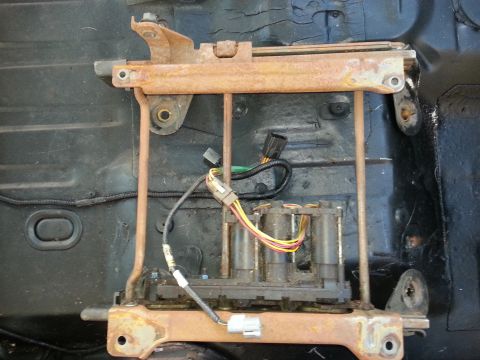1994 Ford Bronco - This is a power seat mechanism with its wiring harness, showing signs of rust and wear.