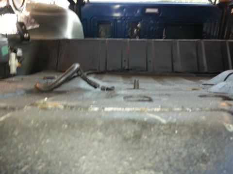 1994 Ford Bronco - Interior view of a vehicle's floor, showing exposed metal and wiring conduit.