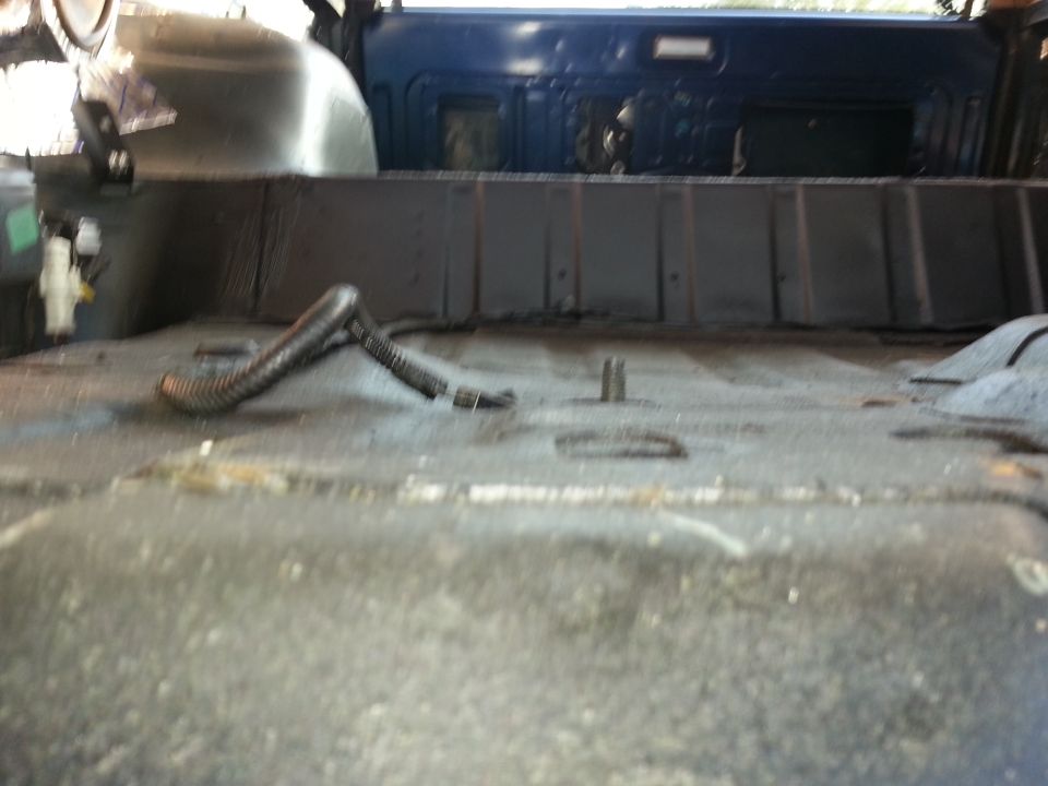 Interior floor of a vehicle with a black corrugated tube on the floor