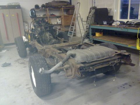 1984 Ford Bronco - The chassis and engine of a 1984 Ford Bronco are shown during a rebuild process in a workshop.