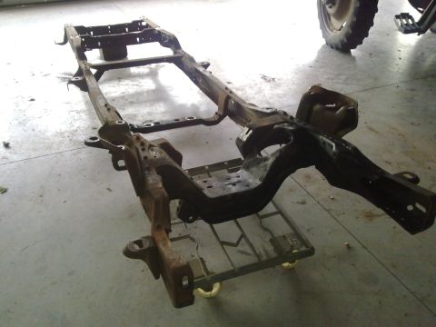 1984 Ford Bronco - This is a vehicle frame assembly, not a complete vehicle, shown on a dolly.