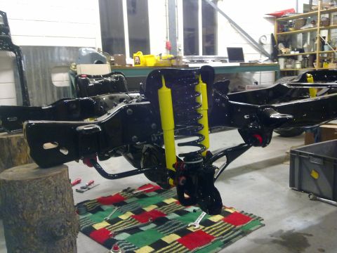 1984 Ford Bronco - The chassis and suspension components of a vehicle are shown, possibly undergoing restoration or repair.