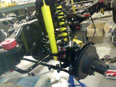 1984 Ford Bronco - Close-up of a vehicle's front suspension and chassis during a rebuild.