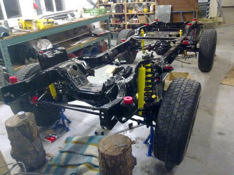 1984 Ford Bronco - Vehicle chassis undergoing repair, showing suspension components and frame structure.