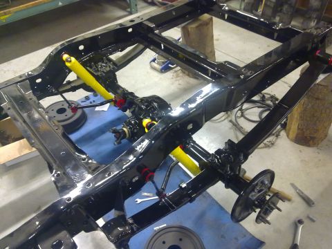 1984 Ford Bronco - Vehicle chassis undergoing a rebuild, new yellow shock absorbers and a freshly painted frame.