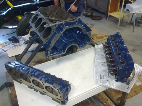 1984 Ford Bronco - Disassembled engine components, including a block and cylinder heads, are laid out for inspection or rebuilding.