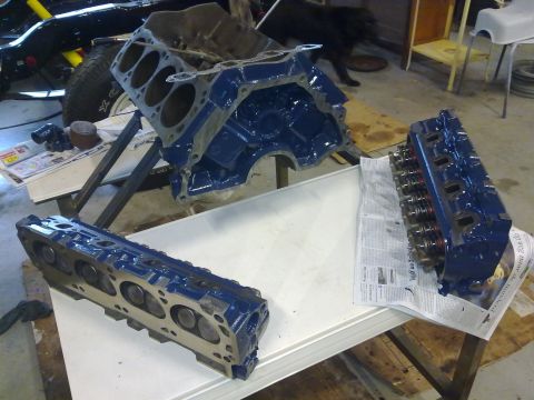 1984 Ford Bronco - Engine block and cylinder heads disassembled for rebuild, with a partial vehicle in the background.