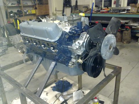 1984 Ford Bronco - A V8 engine is mounted on a metal stand in a workshop, ready for work.