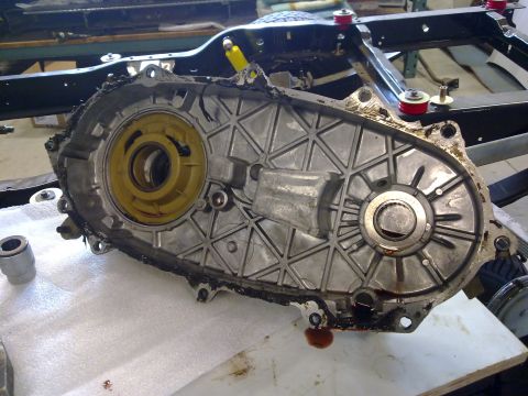 1984 Ford Bronco - Close-up of a disassembled transfer case, showing internal gears and housing, with visible oil leaks.
