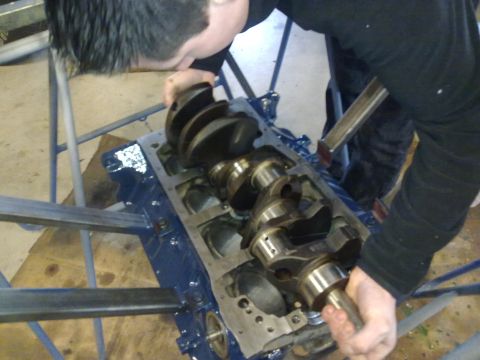 1984 Ford Bronco - Engine crankshaft being installed into a blue engine block.