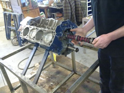 1984 Ford Bronco - Mechanic installs camshaft into engine block during rebuild process.