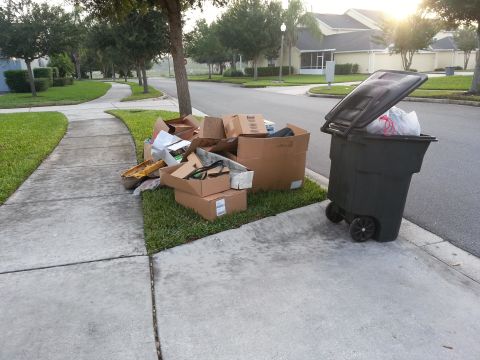 1994 Ford Bronco - Cardboard boxes and a trash bin are placed on the curb for collection on a suburban street.