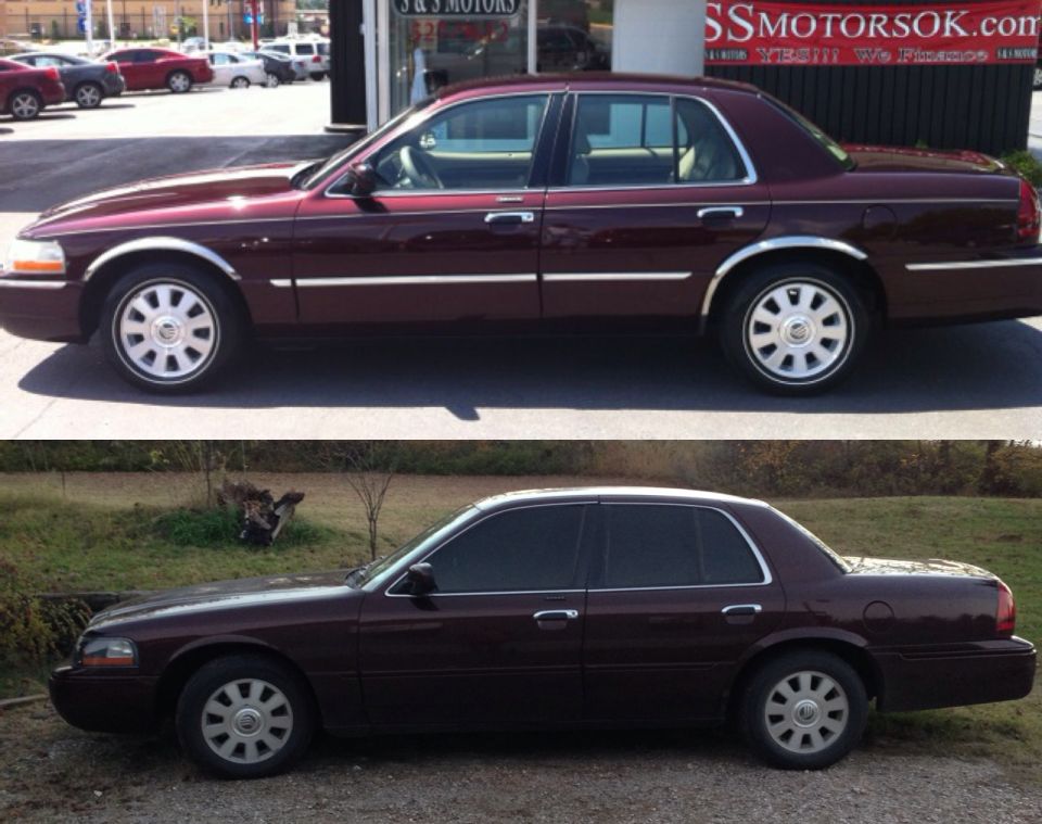 Dark maroon full-size sedan in side profile, shown at a dealership and parked on gravel.