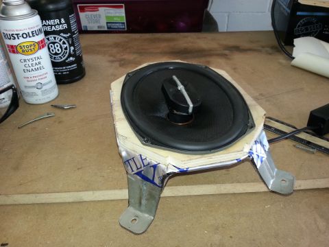 1994 Ford Bronco - A car speaker assembly is shown on a workbench, surrounded by tools and supplies.