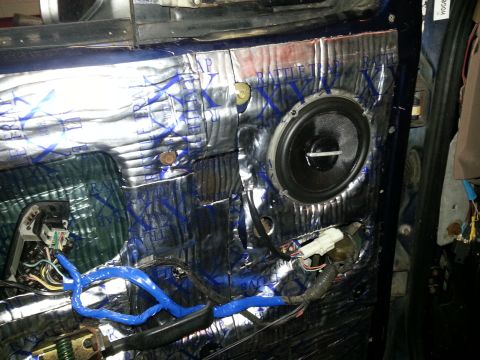 1994 Ford Bronco - The interior of a car door is shown with sound dampening material and a speaker, along with exposed wiring.