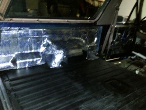 1994 Ford Bronco - Sound deadening material is being applied to the interior side panels of a vehicle.
