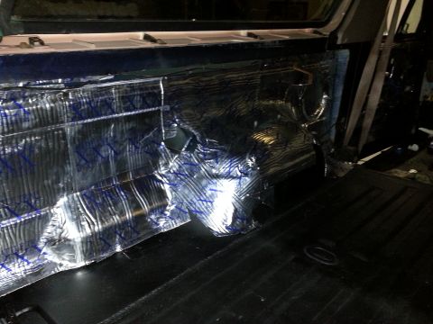 1994 Ford Bronco - Sound dampening material is applied to the interior side panel of a vehicle.
