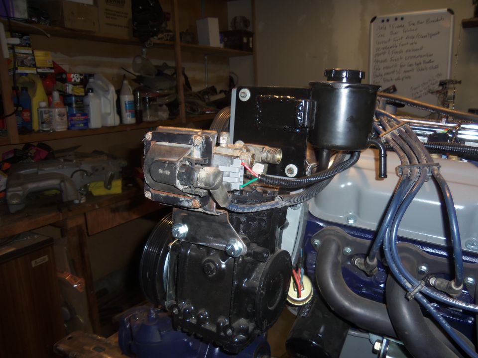 Black engine component with wires and hoses attached
