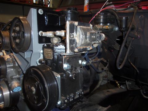 1968 Ford Bronco - Engine components are visible, including a coil, hoses, and pulleys, in this close-up shot.