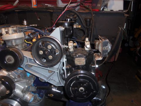 1968 Ford Bronco - This image shows various engine components, including a compressor and distributor, in what appears to be a workshop.