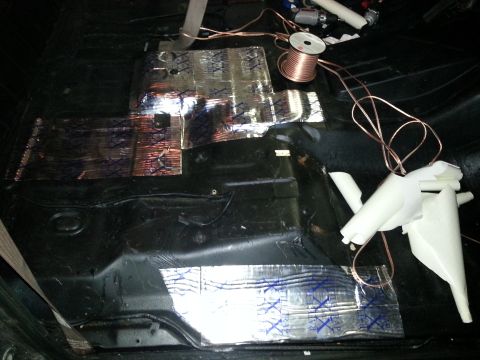 1994 Ford Bronco - Sound deadening material and wiring are being installed on the floor of a vehicle's interior.