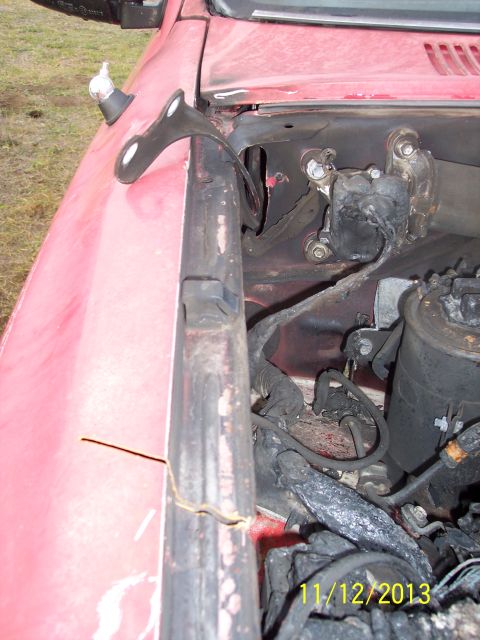 1991 Toyota Pickup/SR5 - The engine bay of a red vehicle shows exposed wiring and engine parts.
