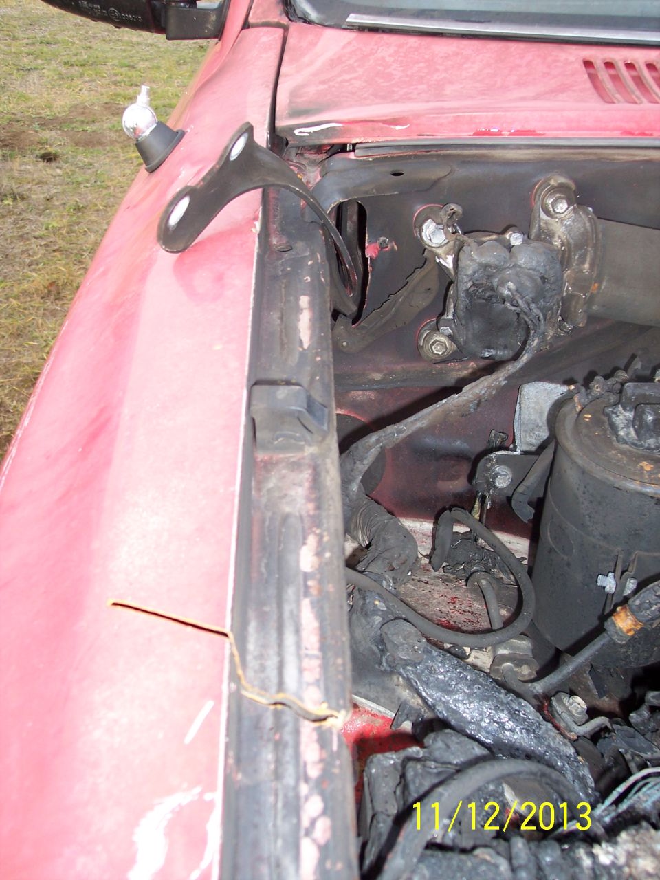 Close-up of red vehicle's engine bay showing wiring and some engine components