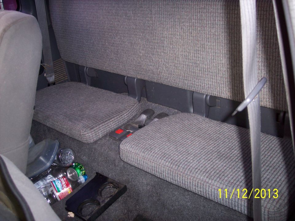 Rear jump seats in a pickup truck, with bottles and a cup holder on the floor