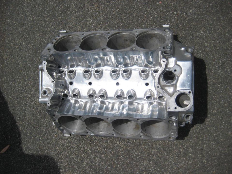 Polished aluminum V8 engine block on asphalt