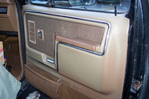 1986 Ford Bronco - Interior door panel details of a vehicle, a fabric insert and storage pockets.