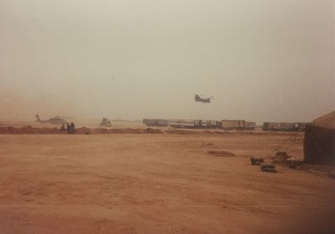 1982 Ford Bronco - Military vehicles and aircraft are visible in a desert environment with a train in the background.