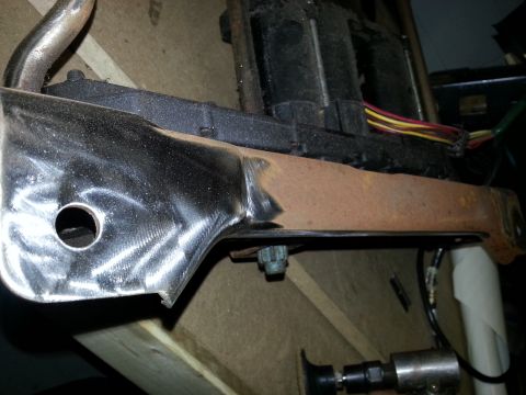 1994 Ford Bronco - A close-up view of a vehicle seat bracket with exposed wiring and signs of rust.